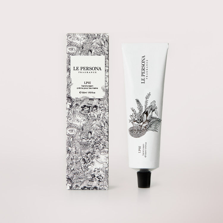 Le Persona LP02 white hand-cream tube with black cap and a black-and-white illustration of a bird among leafy plants, standing beside its densely illustrated carton on pale blush.